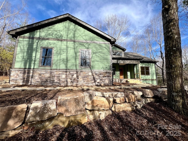 view of side of home featuring stone siding