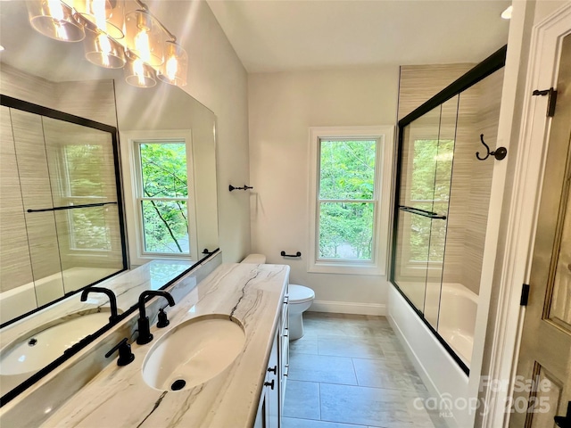 full bathroom with vanity, toilet, a chandelier, baseboards, and enclosed tub / shower combo