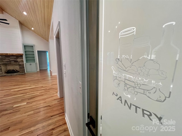 corridor featuring light wood-type flooring, lofted ceiling, recessed lighting, wooden ceiling, and baseboards