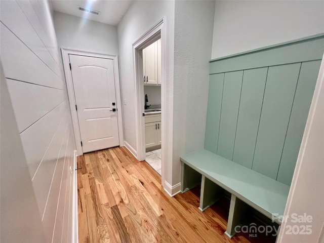 mudroom with light wood-type flooring and a sink