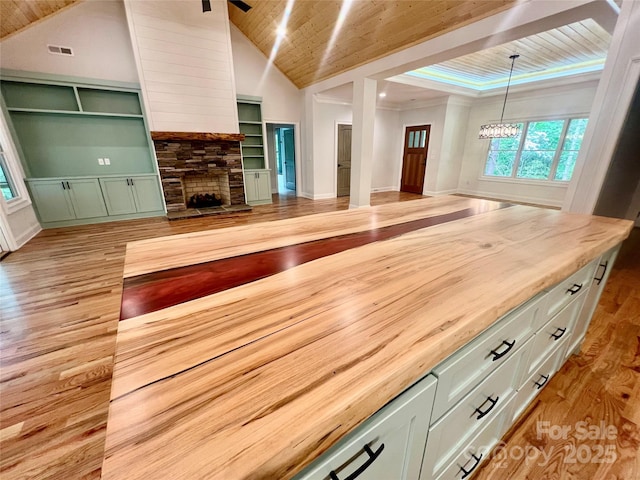 unfurnished living room with wood ceiling, light wood-style flooring, a fireplace, a chandelier, and high vaulted ceiling