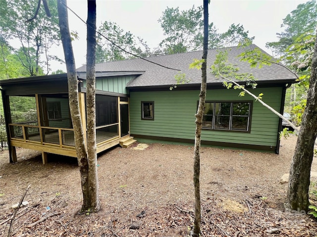 back of house with a sunroom and a shingled roof