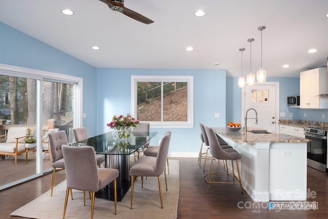 dining room featuring ceiling fan, sink, and dark wood-type flooring