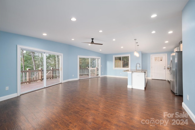 unfurnished living room featuring dark hardwood / wood-style flooring, ceiling fan, lofted ceiling, and sink