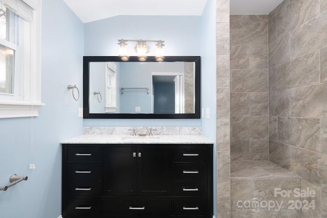 bathroom featuring vanity and lofted ceiling