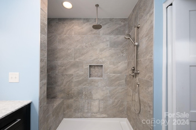 bathroom with vanity and tiled shower