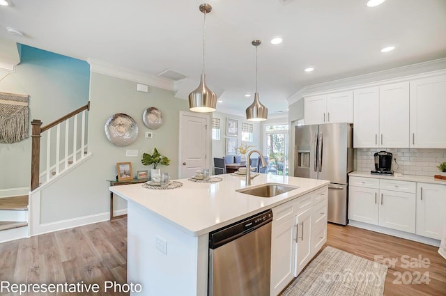 kitchen with sink, stainless steel appliances, an island with sink, white cabinets, and light wood-type flooring