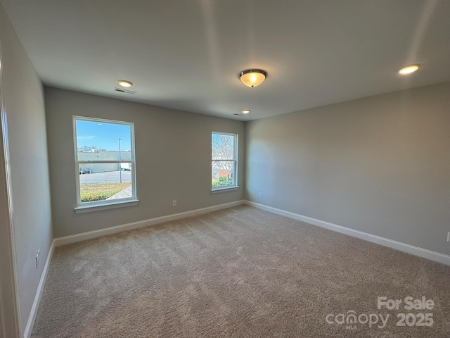 spare room featuring baseboards, visible vents, carpet flooring, and recessed lighting