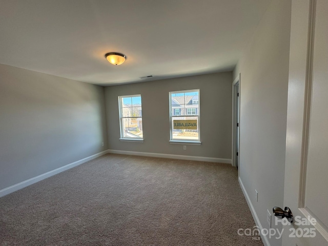 carpeted empty room featuring visible vents and baseboards