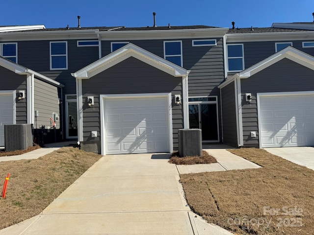 view of front of property featuring concrete driveway and cooling unit