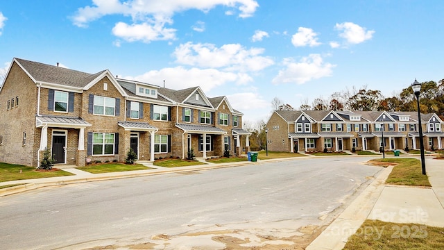 view of property with a residential view, a standing seam roof, and brick siding