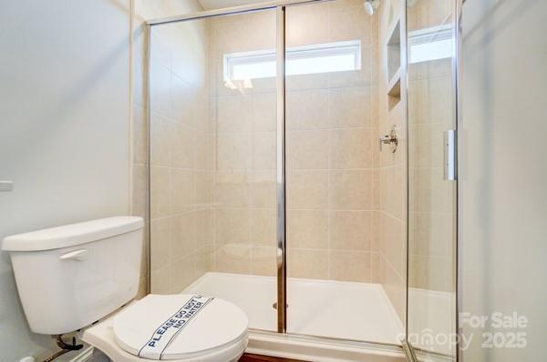 full bath with a shower stall and toilet