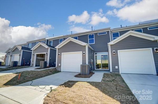 multi unit property featuring cooling unit and concrete driveway