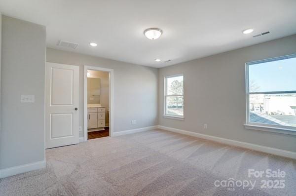 unfurnished bedroom featuring carpet, baseboards, and visible vents