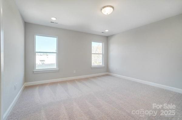 carpeted empty room featuring baseboards and recessed lighting