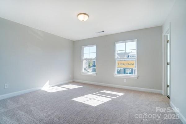 unfurnished room with baseboards, visible vents, and carpet floors