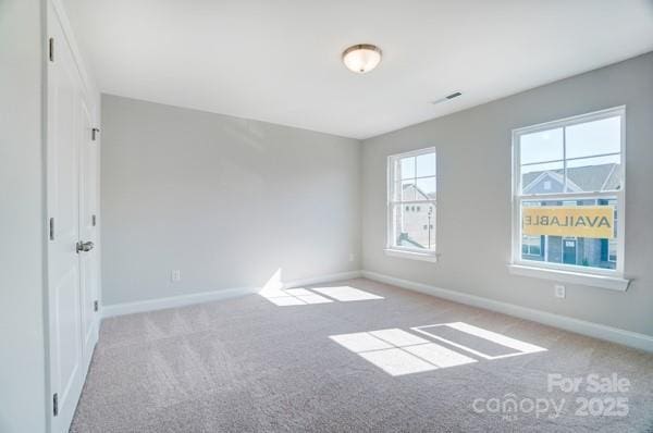 carpeted empty room with baseboards and visible vents