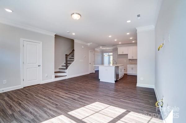 unfurnished living room with crown molding, baseboards, stairs, recessed lighting, and dark wood-style floors