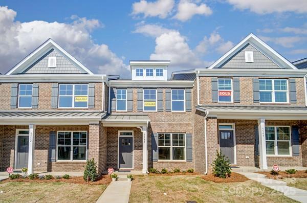 view of front of home featuring brick siding, a standing seam roof, and metal roof