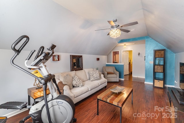 living area with a ceiling fan, baseboards, dark wood-style floors, and vaulted ceiling