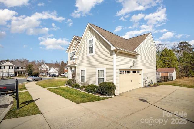 view of home's exterior with a residential view, concrete driveway, a shingled roof, and a lawn