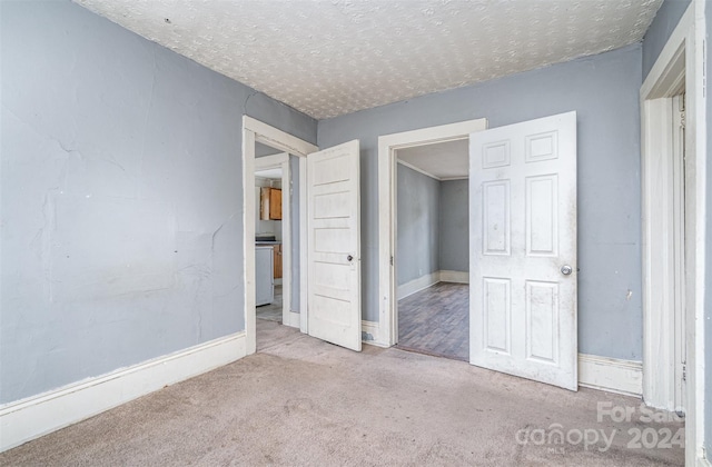 unfurnished bedroom featuring light carpet and a textured ceiling