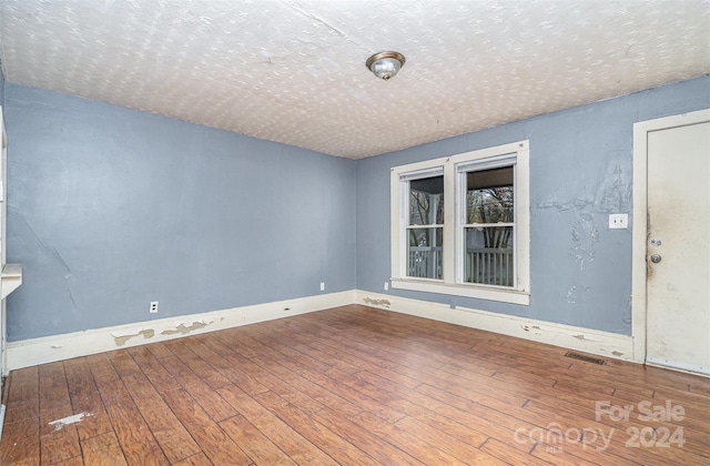 unfurnished room with hardwood / wood-style floors