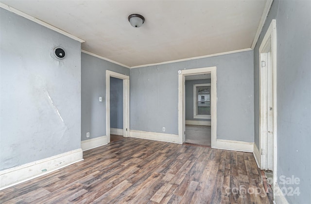 empty room featuring dark hardwood / wood-style floors and ornamental molding