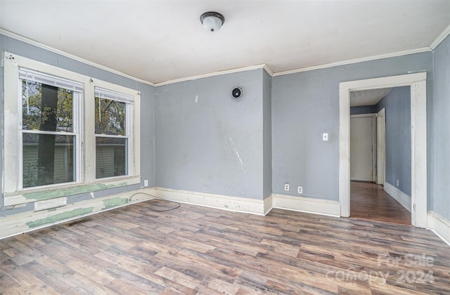 spare room with crown molding and wood-type flooring