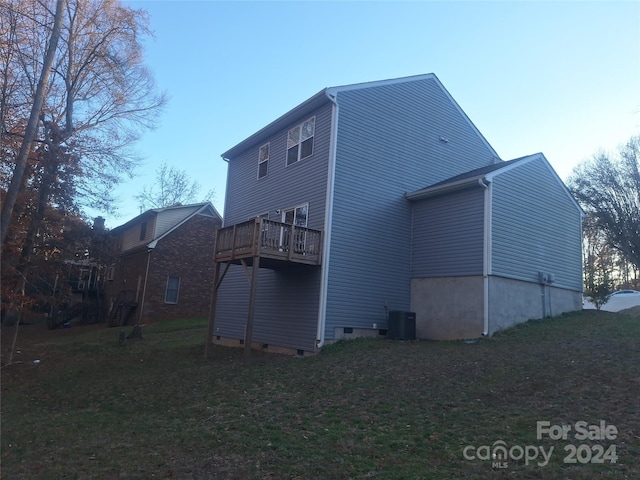 rear view of property with a yard and central AC