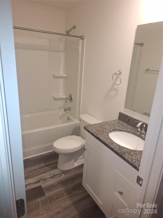 full bathroom featuring hardwood / wood-style flooring, vanity, toilet, and bathtub / shower combination