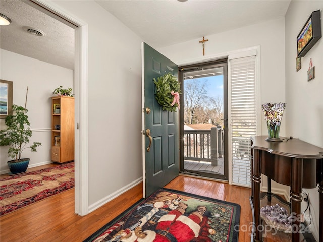 foyer with wood-type flooring and a textured ceiling