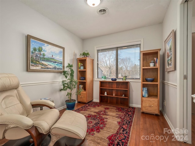 sitting room with dark wood-type flooring