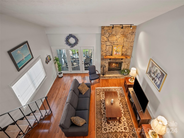 living room with dark hardwood / wood-style flooring, french doors, rail lighting, and a fireplace