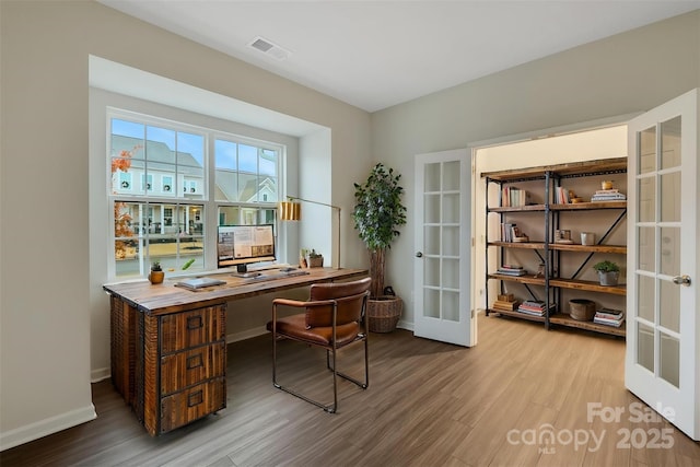 office with hardwood / wood-style flooring and french doors