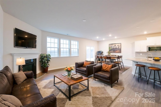 living room with sink and light hardwood / wood-style flooring