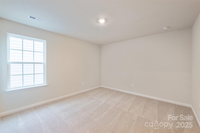 unfurnished room featuring light colored carpet