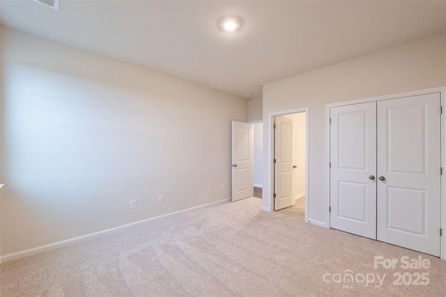 unfurnished bedroom with a closet and light colored carpet