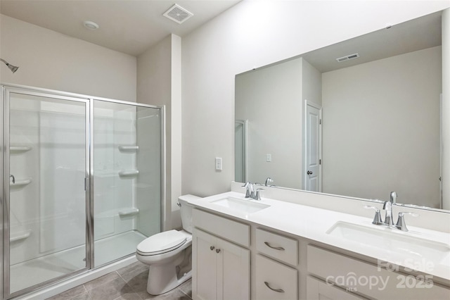 bathroom with tile patterned flooring, vanity, toilet, and walk in shower