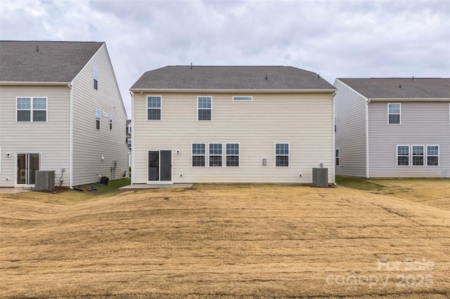 back of property with a yard and central air condition unit