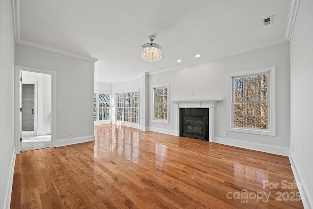 unfurnished living room with an inviting chandelier, ornamental molding, and hardwood / wood-style flooring