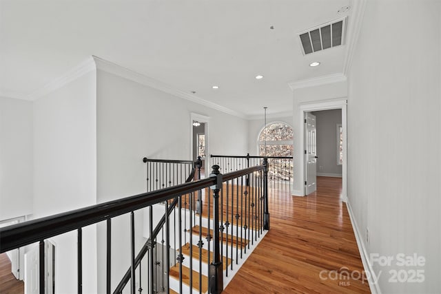 corridor with ornamental molding and hardwood / wood-style flooring