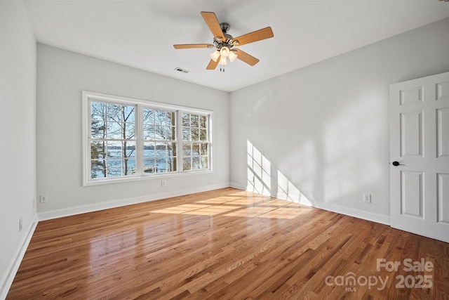 empty room with hardwood / wood-style floors and ceiling fan