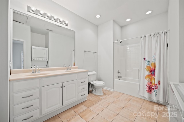 full bathroom featuring stacked washer / dryer, toilet, shower / bath combo, tile patterned floors, and vanity