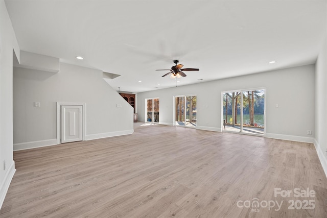 unfurnished living room featuring ceiling fan and light wood-type flooring