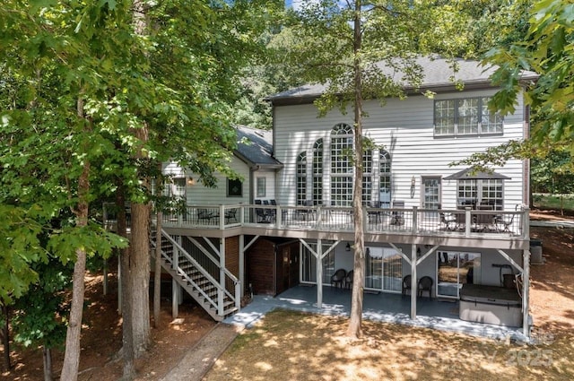 rear view of property featuring a deck, central air condition unit, and a patio area