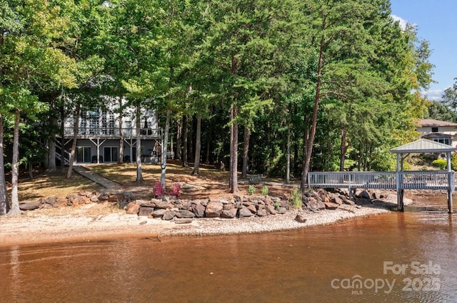 exterior space with a gazebo and a deck with water view