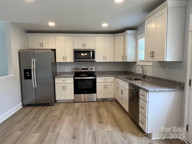 718 Park Ave, Salisbury, NC 28144 - kitchen with appliances with stainless steel finishes, a sink, light wood-style flooring, stone counters, and white cabinets