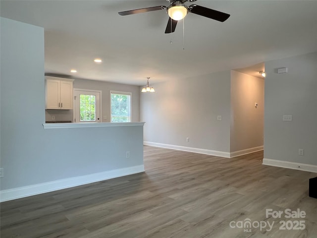718 Park Ave, Salisbury, NC 28144 - unfurnished living room with a ceiling fan, wood finished floors, baseboards, recessed lighting, and a chandelier