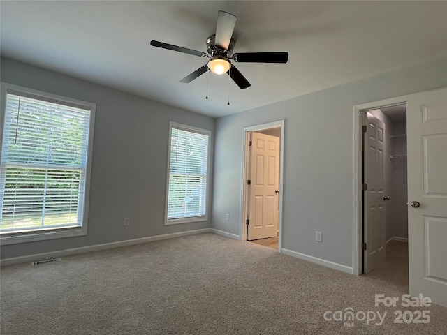 718 Park Ave, Salisbury, NC 28144 - unfurnished bedroom featuring a spacious closet, multiple windows, baseboards, and carpet